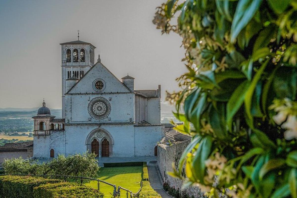 uma igreja branca com uma torre do relógio em uma colina