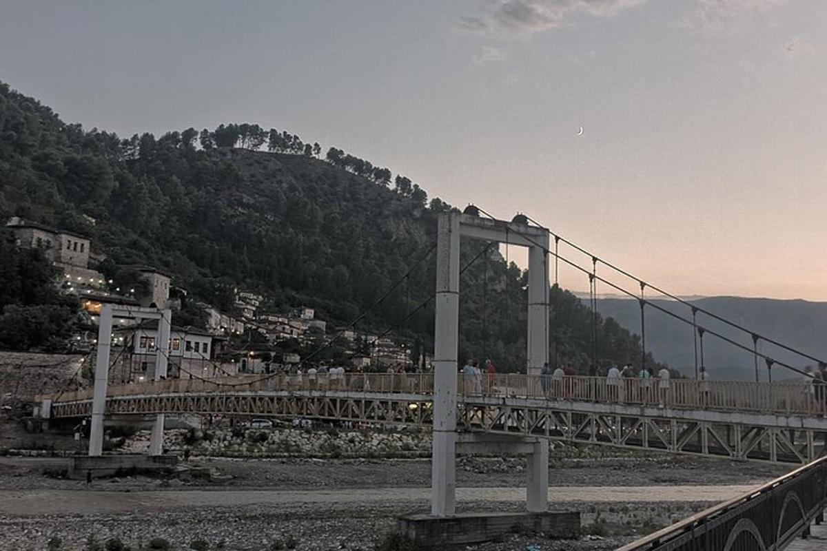 μια γέφυρα πάνω από ένα βουνό με ανθρώπους να περπατούν πάνω της