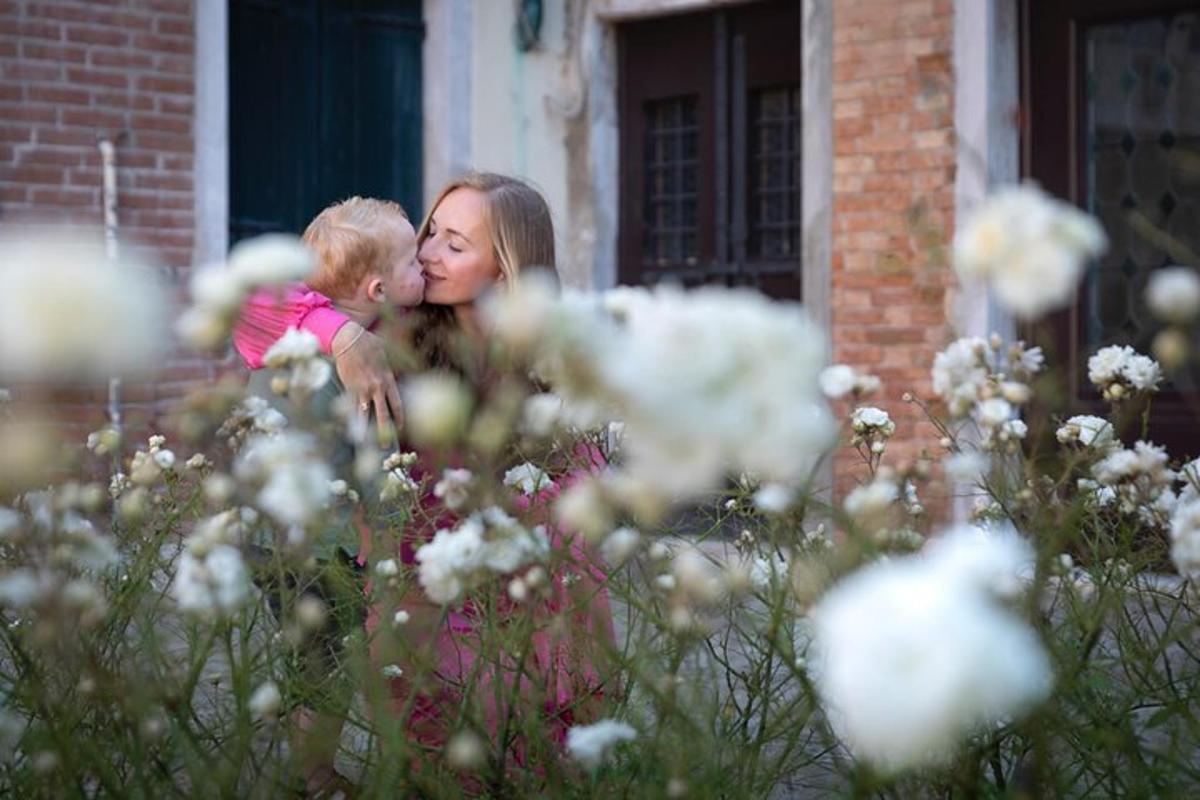una donna che tiene in braccio un bambino e lo bacia
