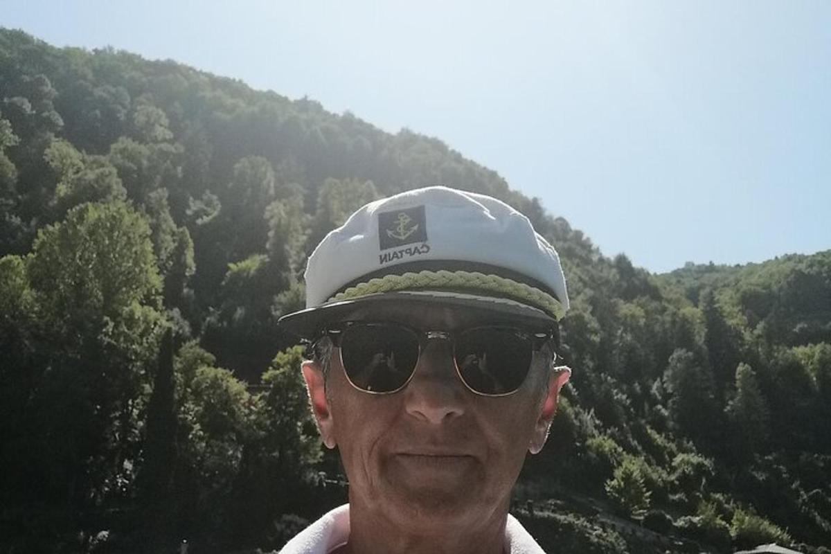 Un hombre con sombrero y gafas de sol frente a una montaña.