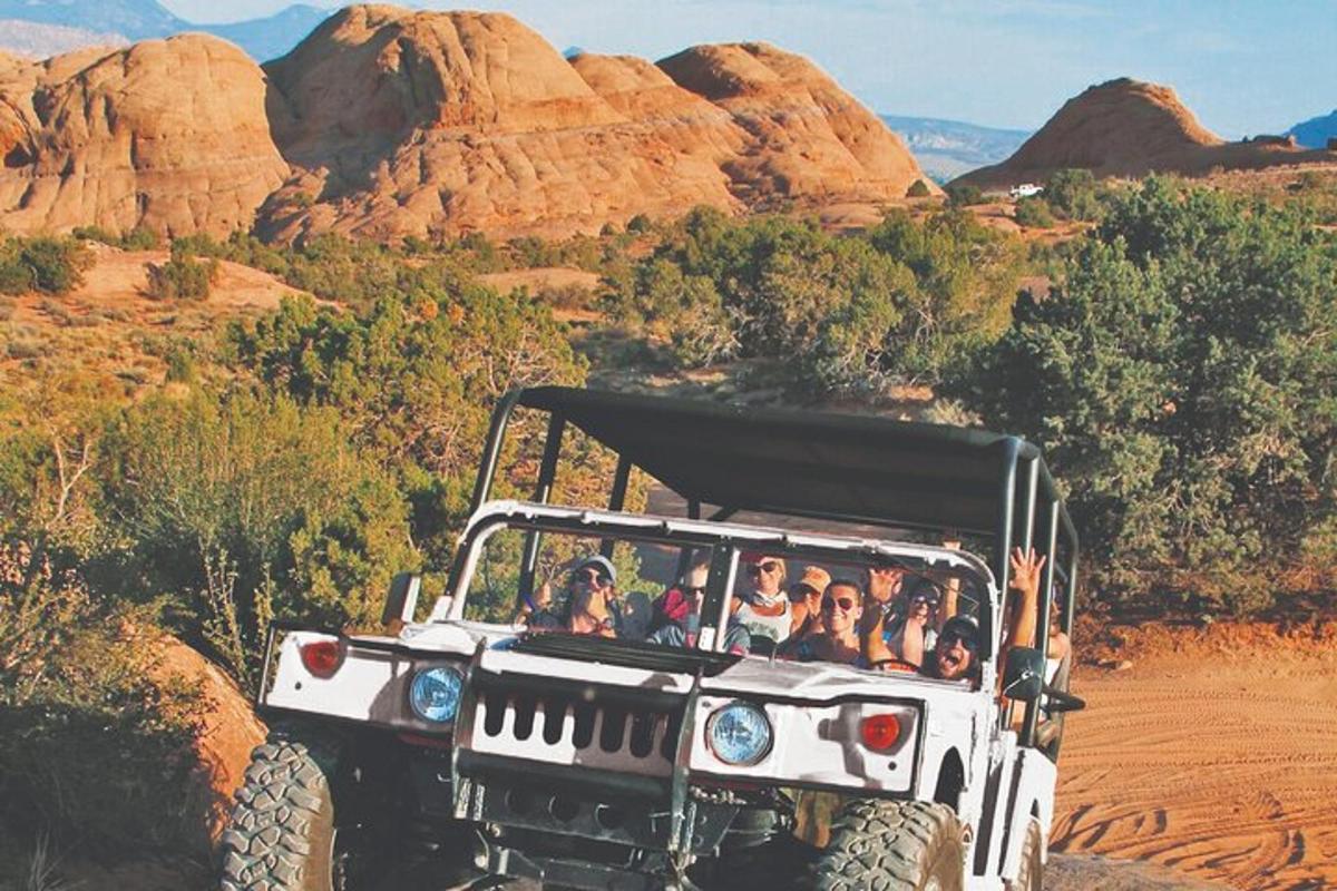 a group of people riding in a jeep in the desert