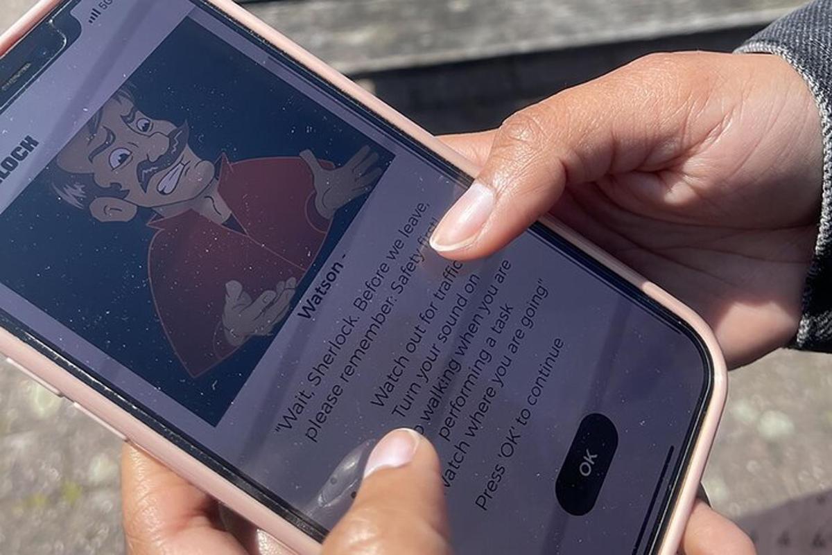 una persona que sosté un telèfon mòbil amb un dibuix animat a la pantalla