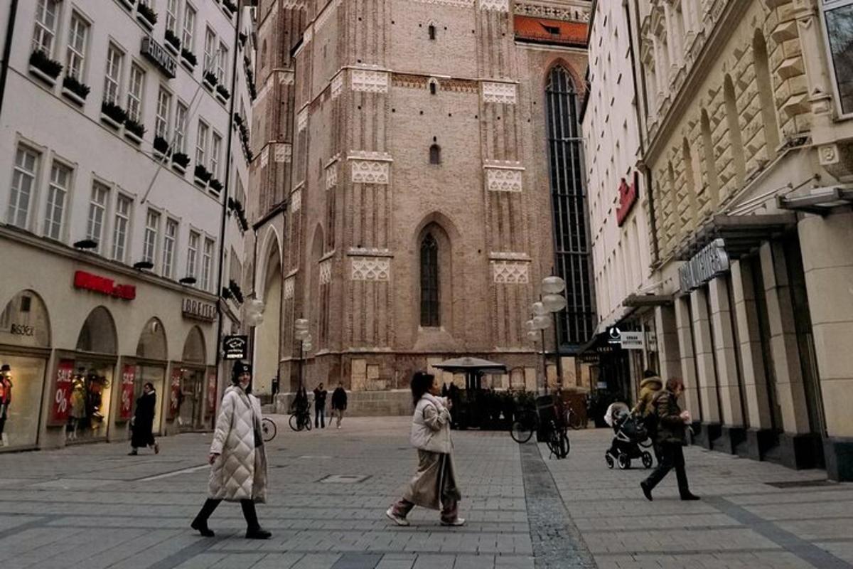 divi cilvēki iet pa ielu ēkas priekšā