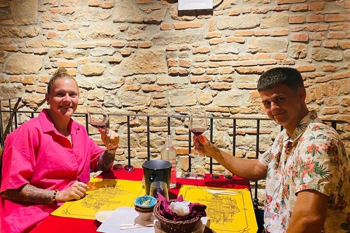 muž a žena sedící u stolu se sklenicemi na víno