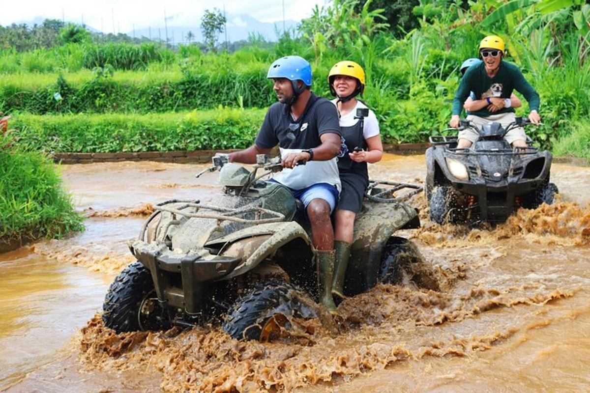 un gruppo di persone che guidano quad nel fango