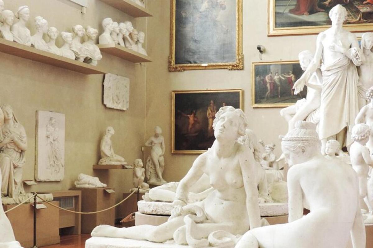 a room with white statues and paintings on the wall