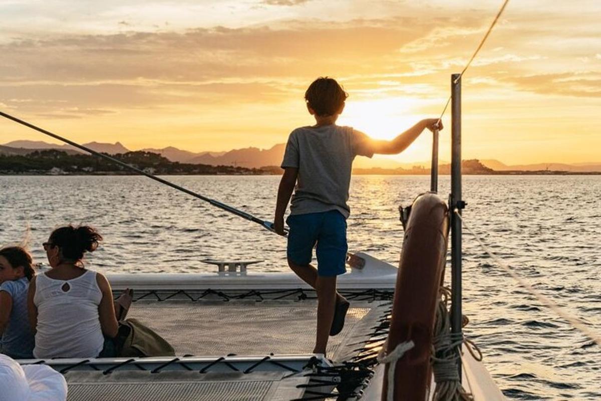 a young boy standing on the front of a boat