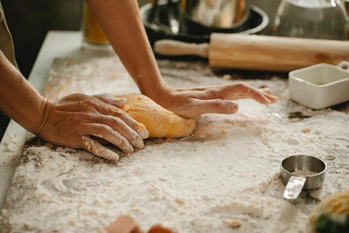 eine Person, die ein Stück Brot auf einer Theke knetet