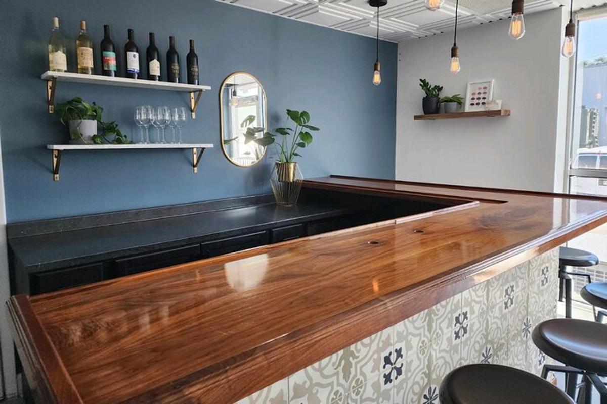 um bar com um balcão de madeira e algumas garrafas de vinho