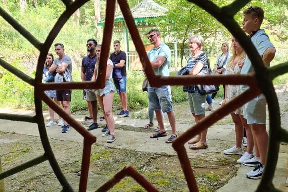 un gruppo di persone in piedi dietro una recinzione metallica