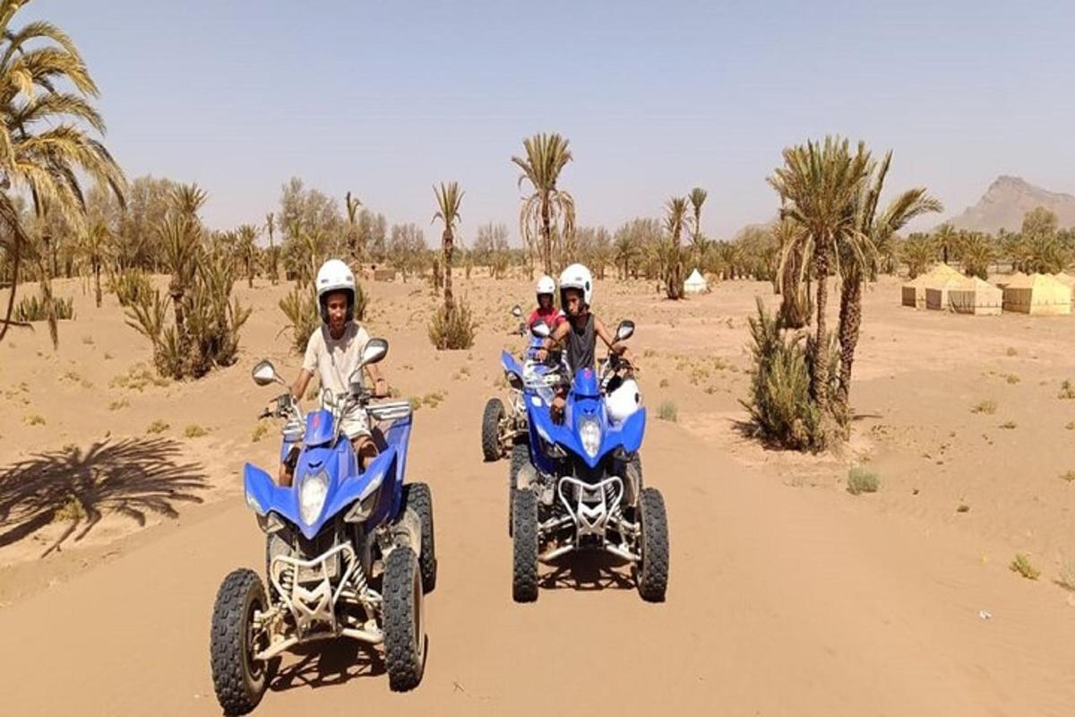 three people riding on atvs in the desert
