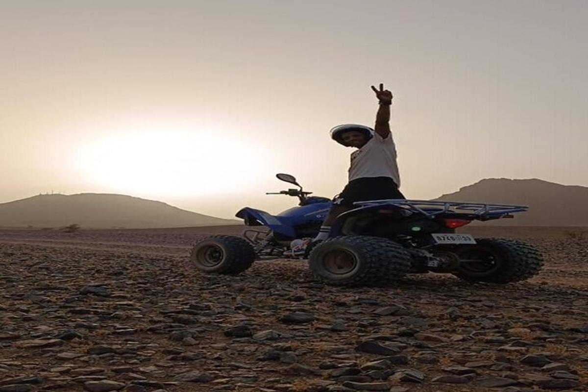a man on a quad bike in the desert