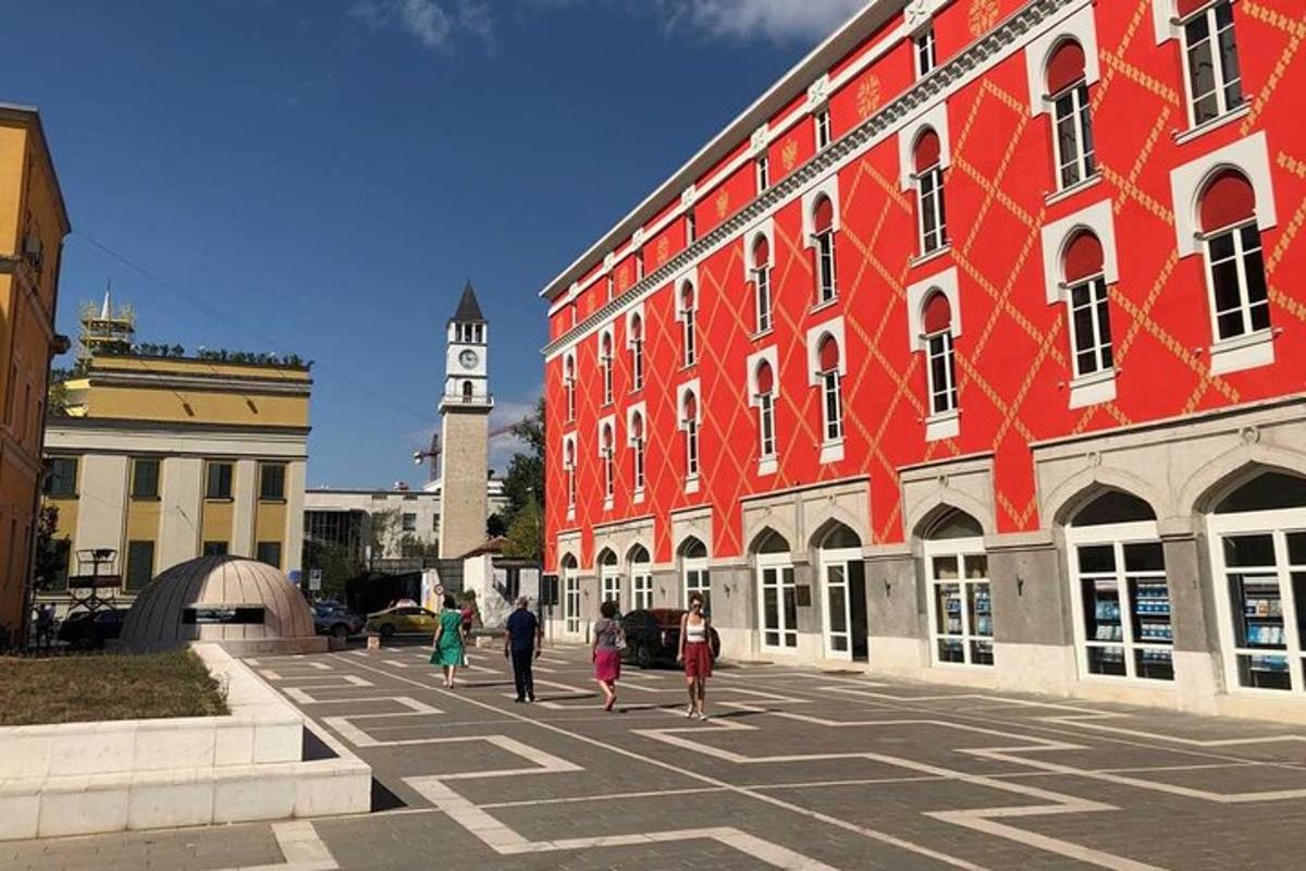 un gruppo di persone che camminano davanti a un edificio rosso
