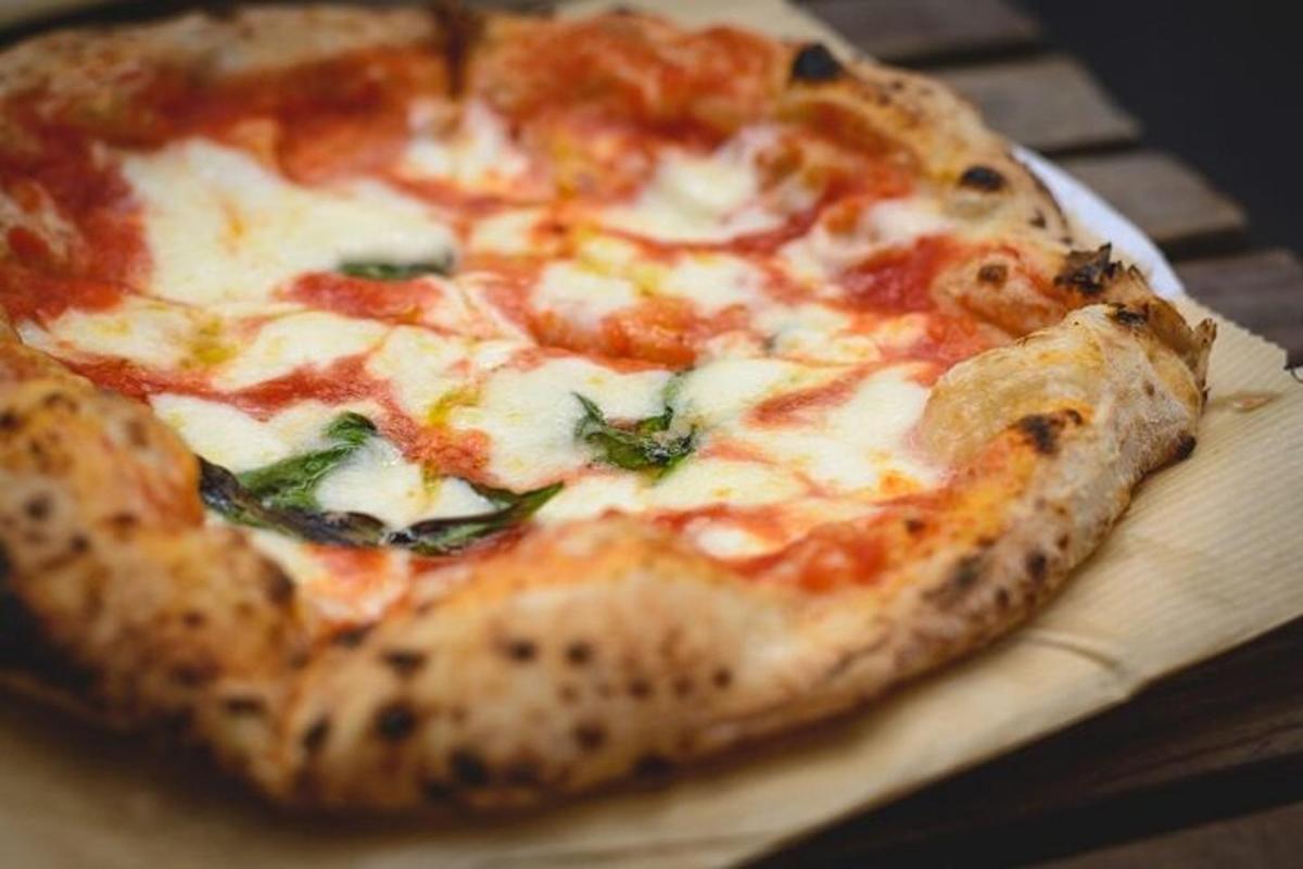 pizza yang terletak di atas papan pemotong kayu