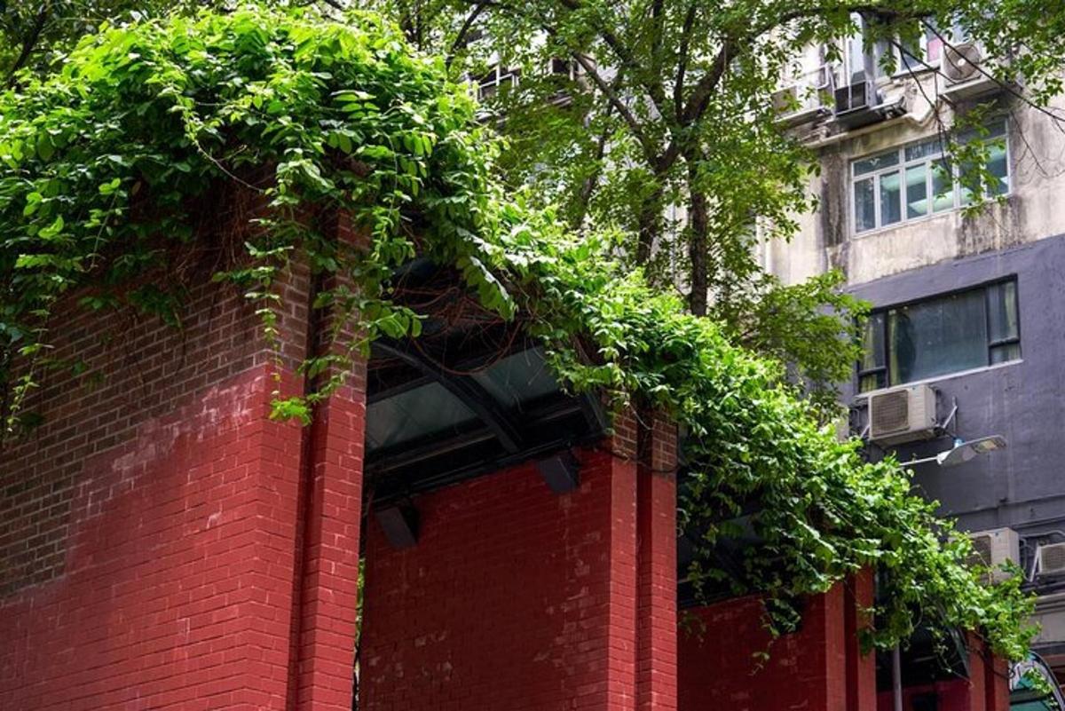 ein Backsteingebäude mit einer grünen Hecke darauf