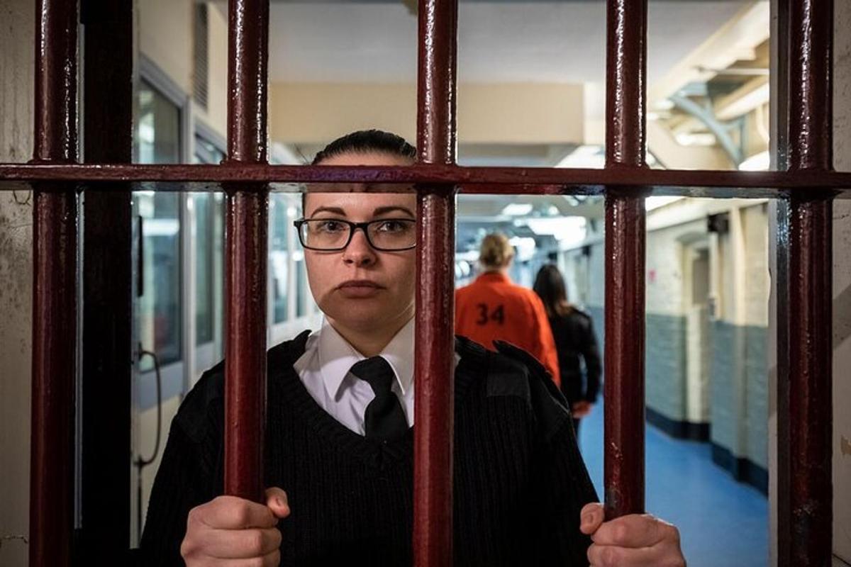 a man in a cage looking through a window