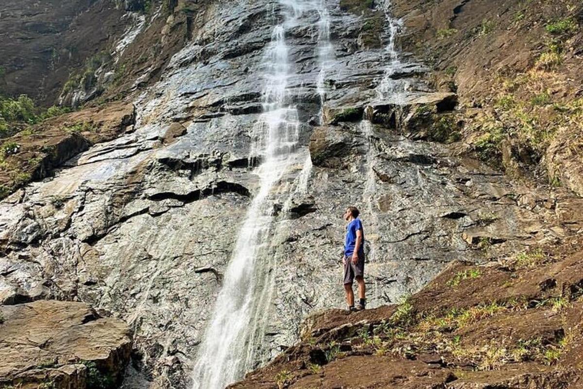 a man standing in front of a waterfall