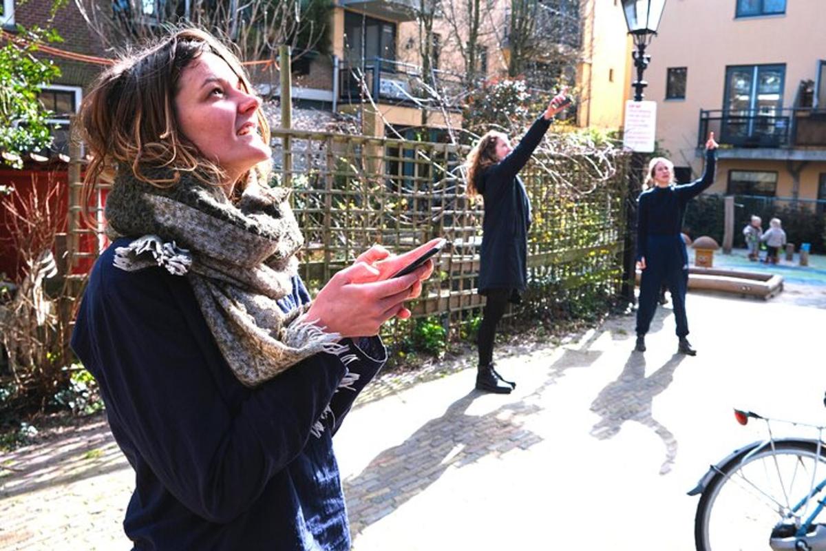 en gruppe kvinner som står på et fortau og ser på en mobiltelefon