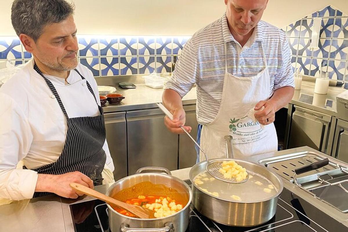 due uomini in cucina che preparano il cibo in una pentola