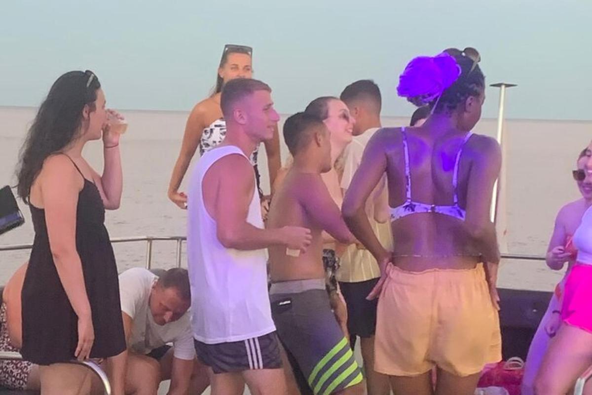 en gruppe mennesker som står på stranden
