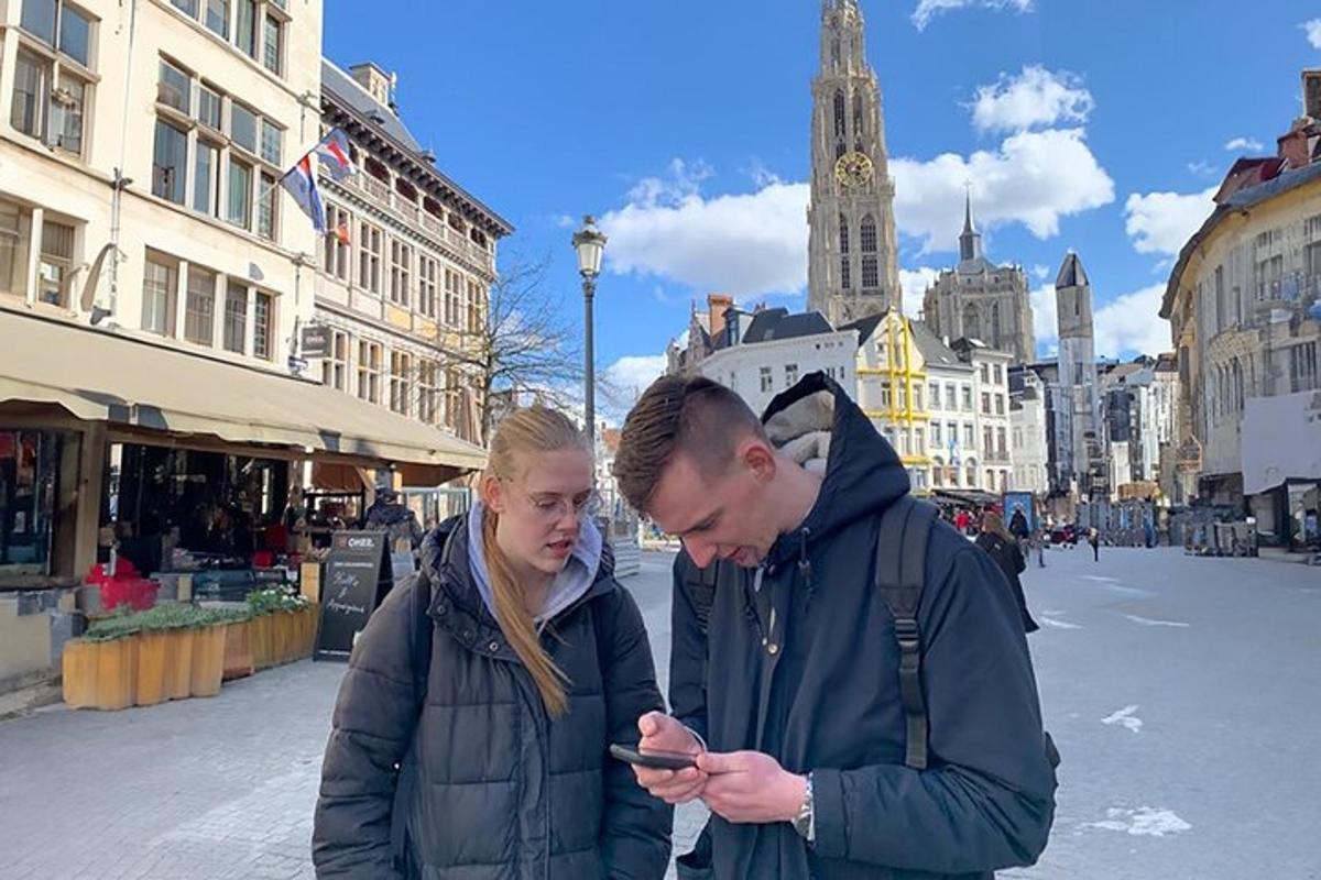 egy férfi és egy nő nézi a mobiltelefonját