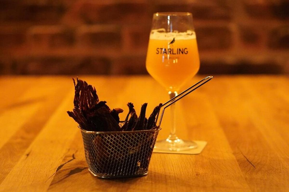 a glass of beer and a basket of pasta on a table