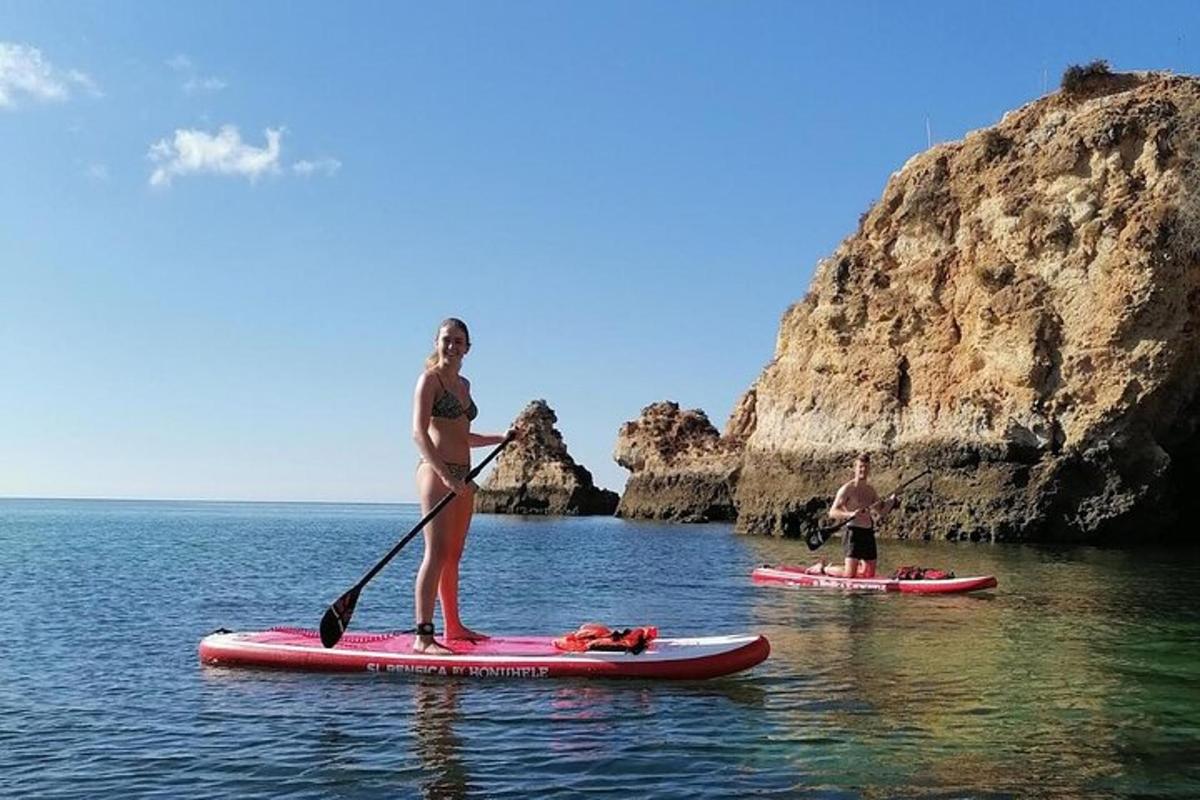 dva lidé stojí na paddleboardech ve vodě