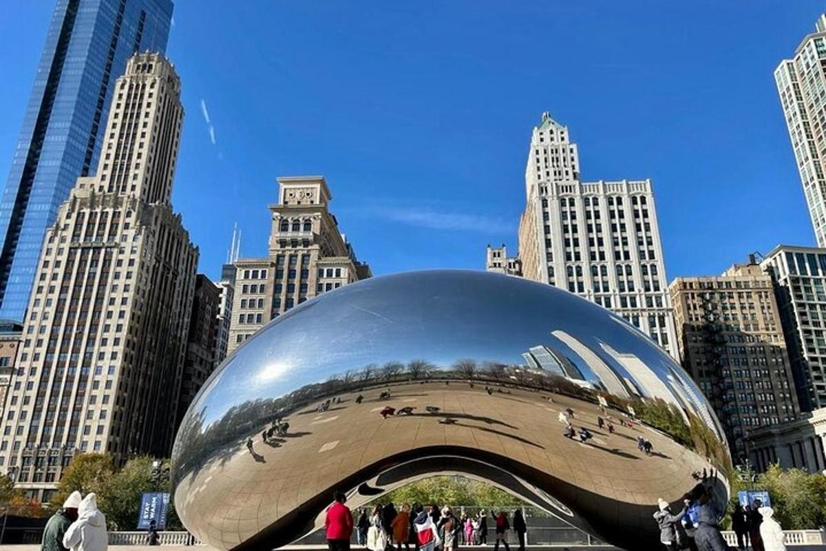 a large silver object in a city with tall buildings