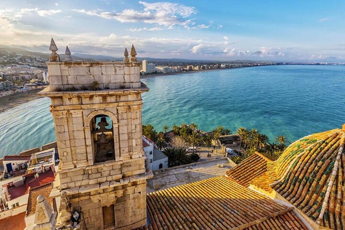 una torre de reloj en la parte superior de un edificio al lado del agua