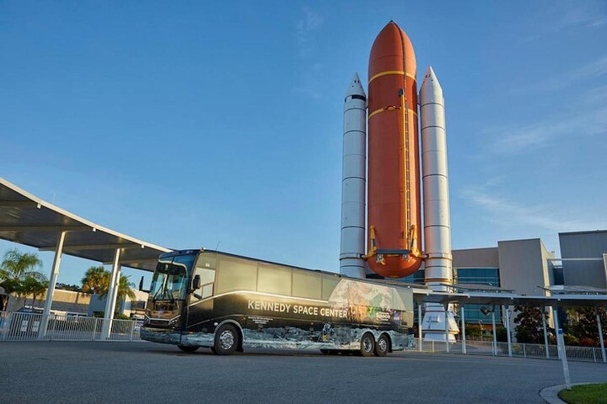 un autobus parcheggiato davanti a un edificio con uno space shuttle