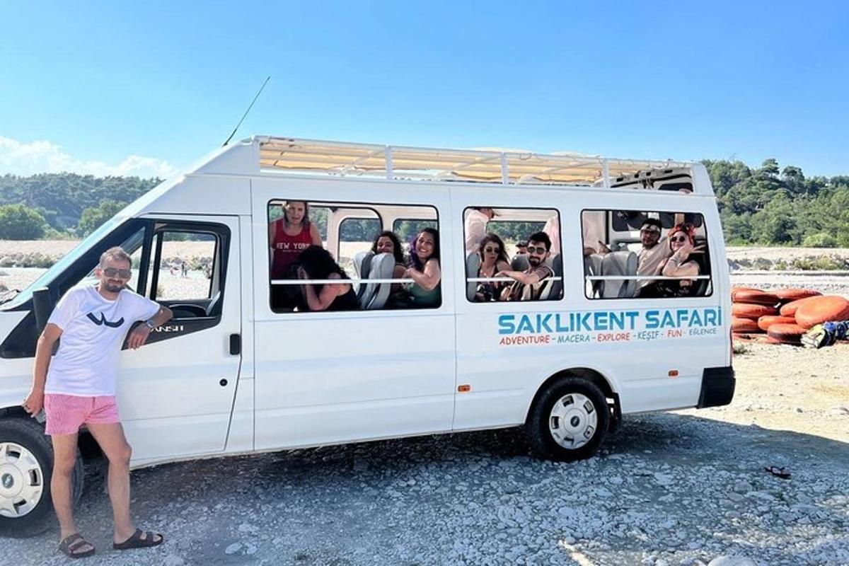 a man standing next to a white van with people inside