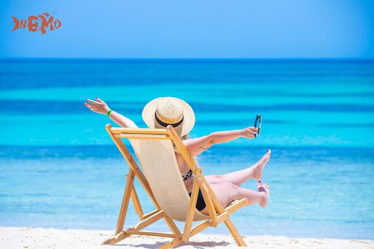 một người phụ nữ đang ngồi trên ghế bãi biển với một chiếc điện thoại di động