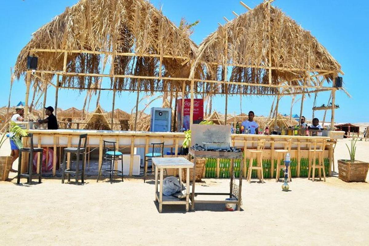 một quán bar có ô dù rơm trên bãi biển