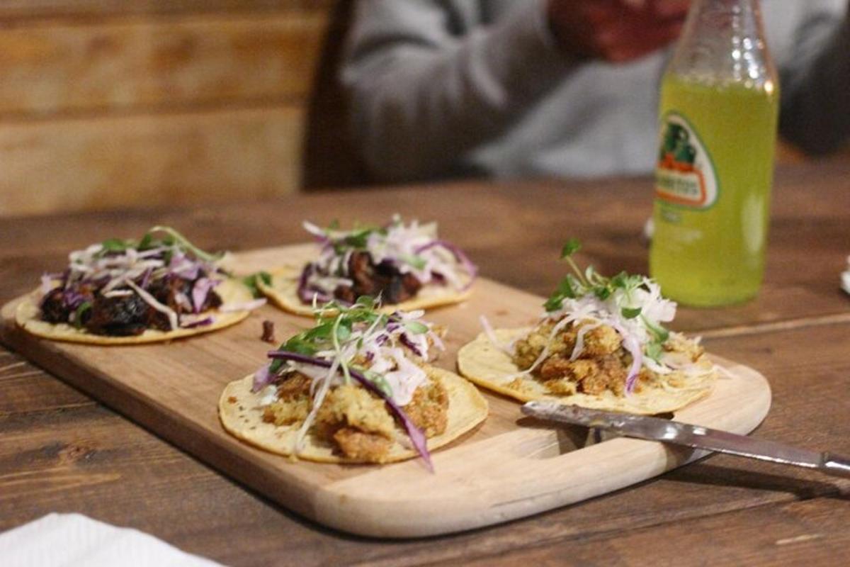Þrír tacos á skurðarbretti á borði