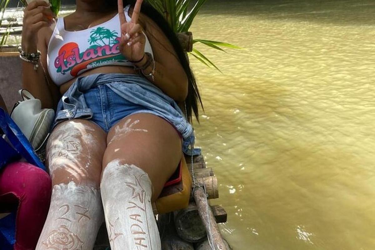 một người phụ nữ có hình xăm trên chân đang ngồi cạnh nước