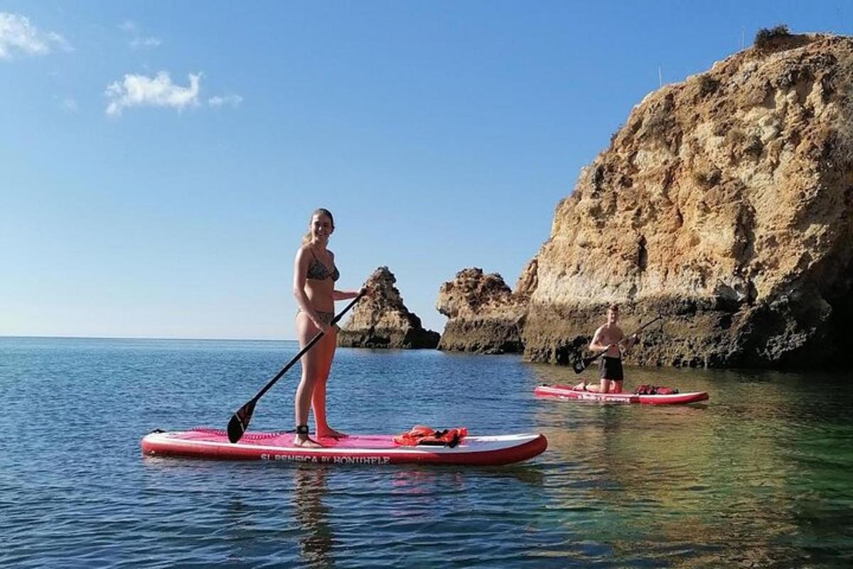 Una mujer parada sobre una tabla de remo en el agua