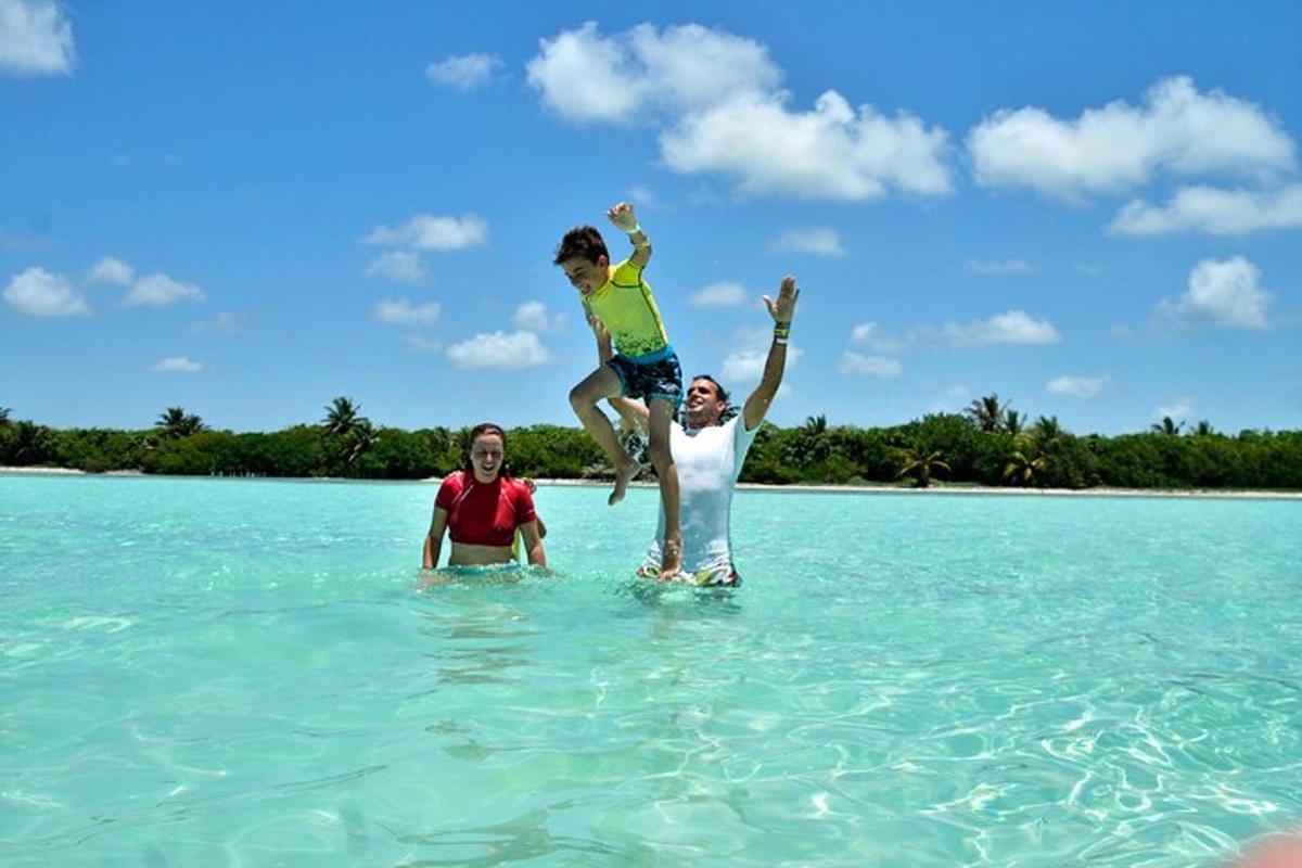 três pessoas brincando na água do oceano