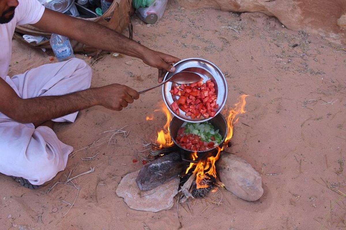 a man cooking food in a pot over a fire