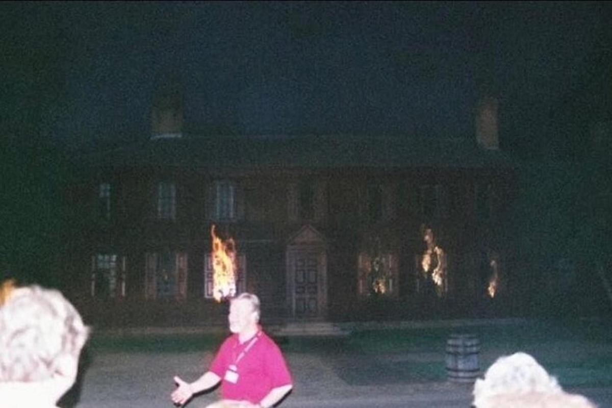 a man sitting in front of a large building at night