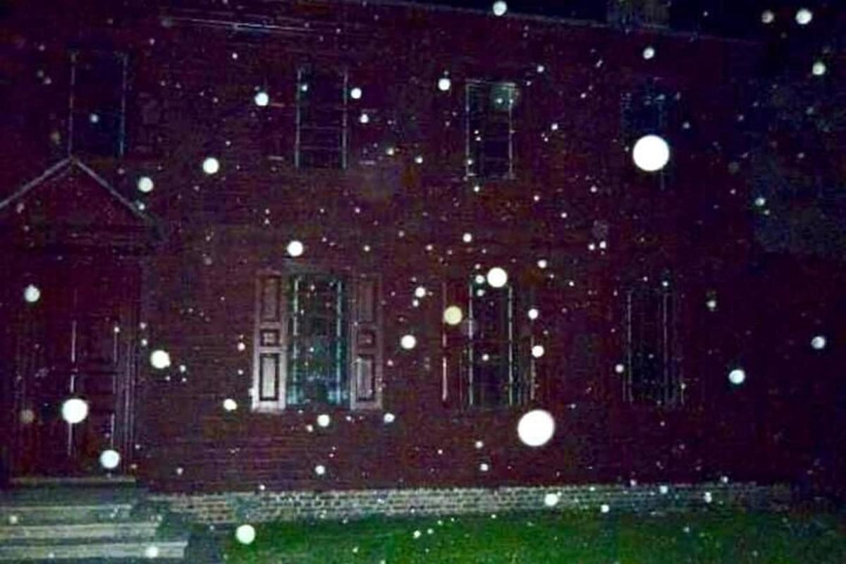 a house with snow falling in front of it