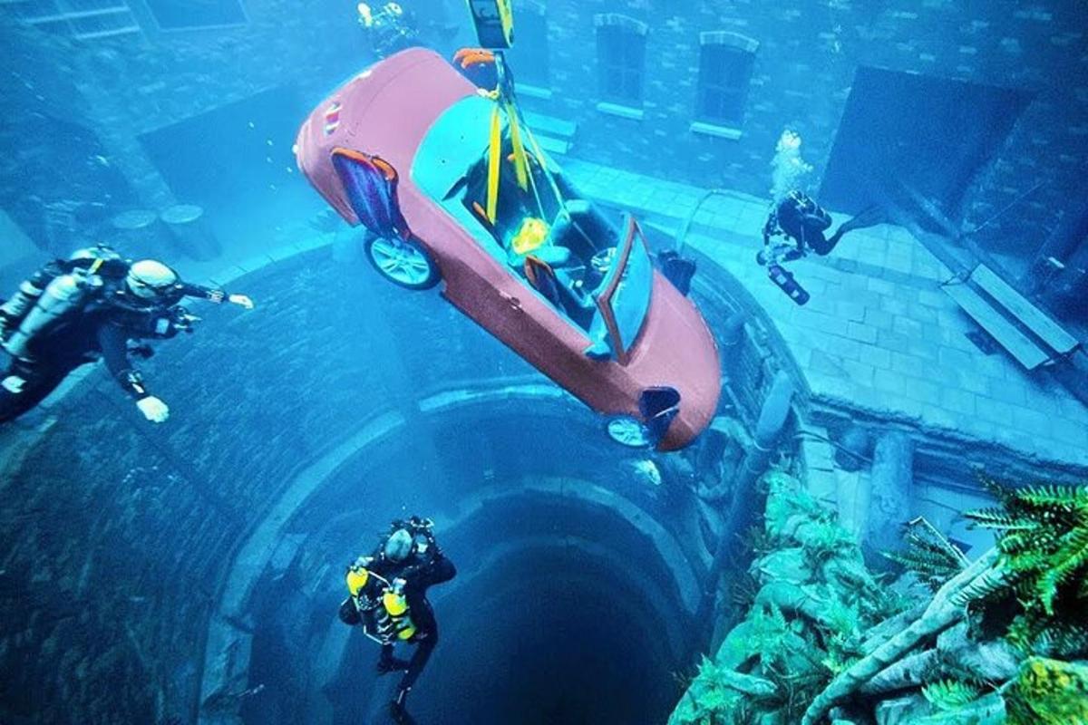 um grupo de pessoas olhando para um carro na água