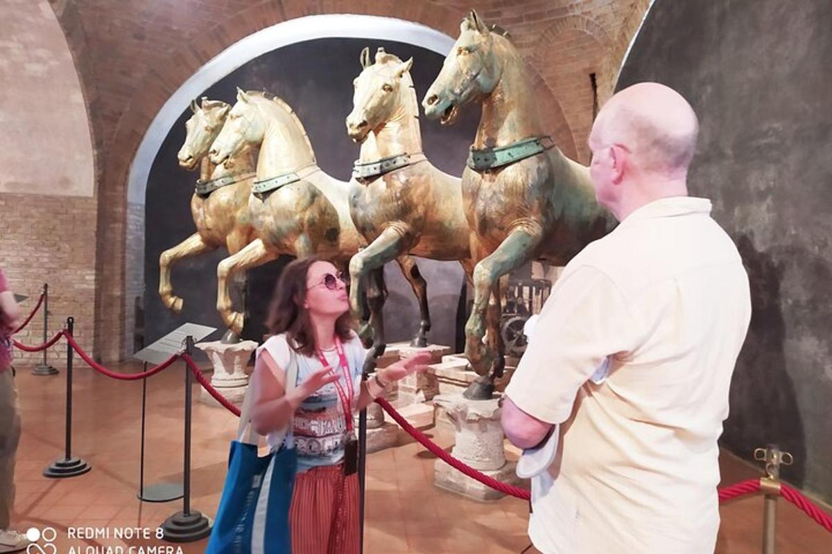 a man and a woman standing in front of a statue of horses
