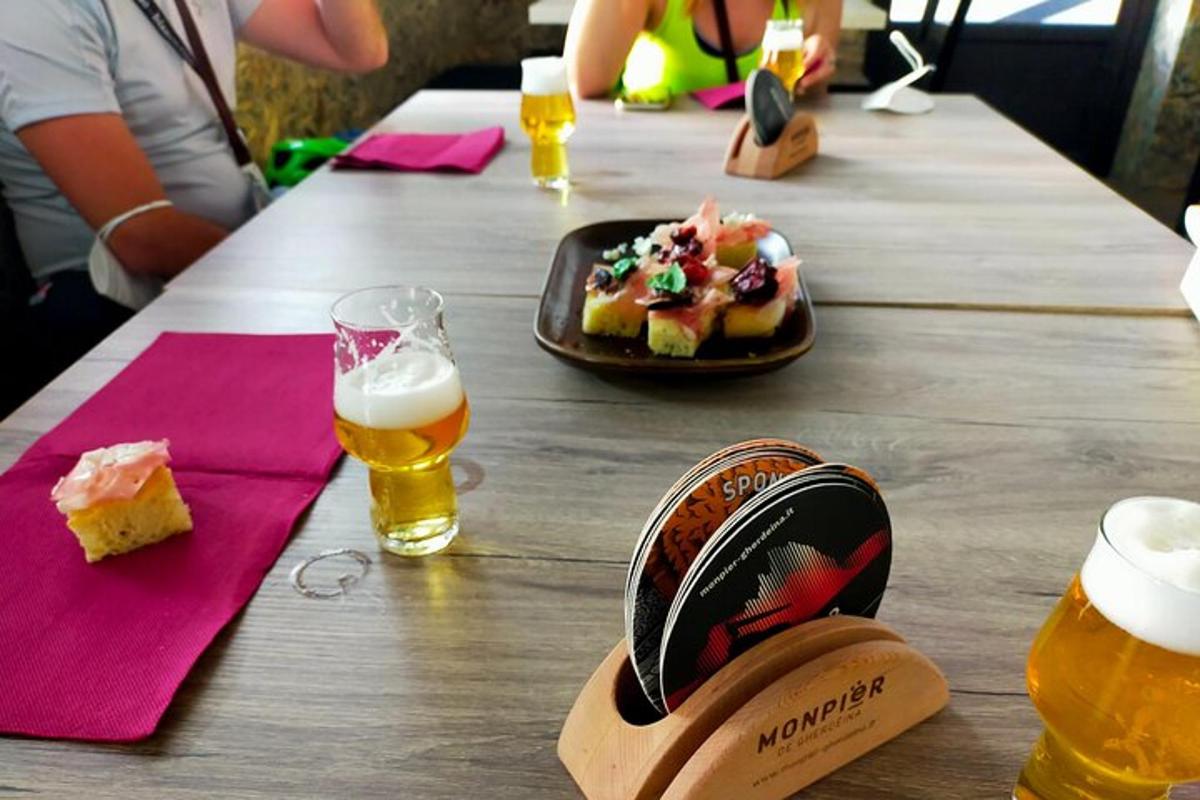 a wooden table with a plate of food and beer