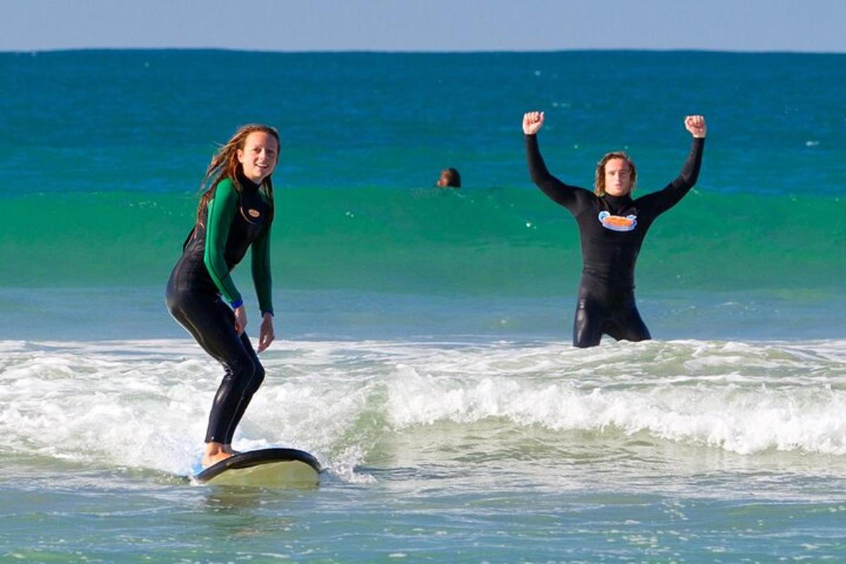 two women standing on surfboards in the ocean