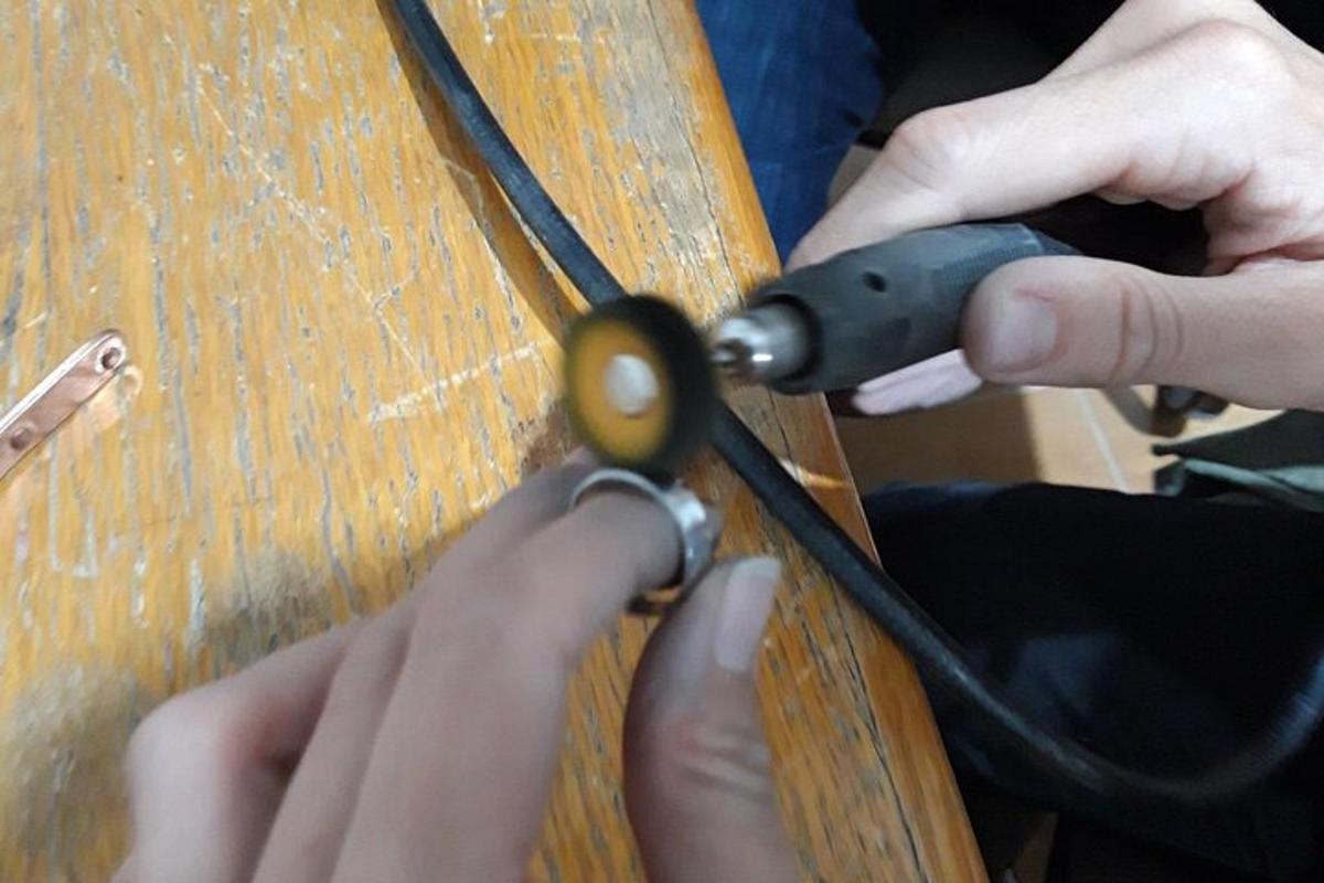 osoba používající nůžky na dřevěném stole
