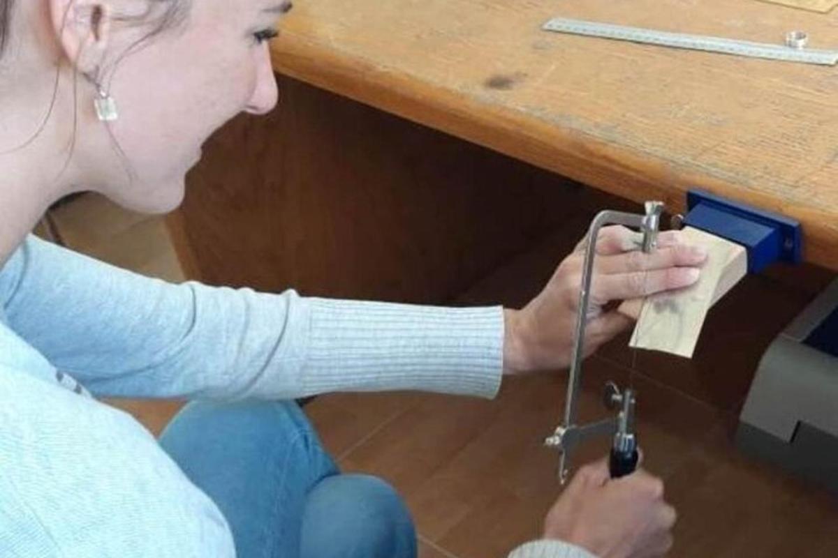 žena sedící na podlaze a držící kovový předmět