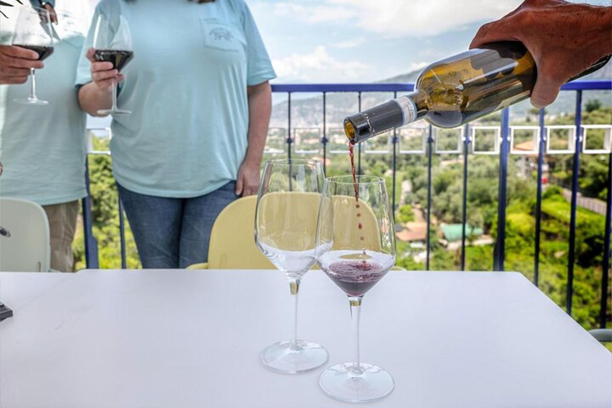 una persona che versa il vino in due bicchieri da vino su un tavolo
