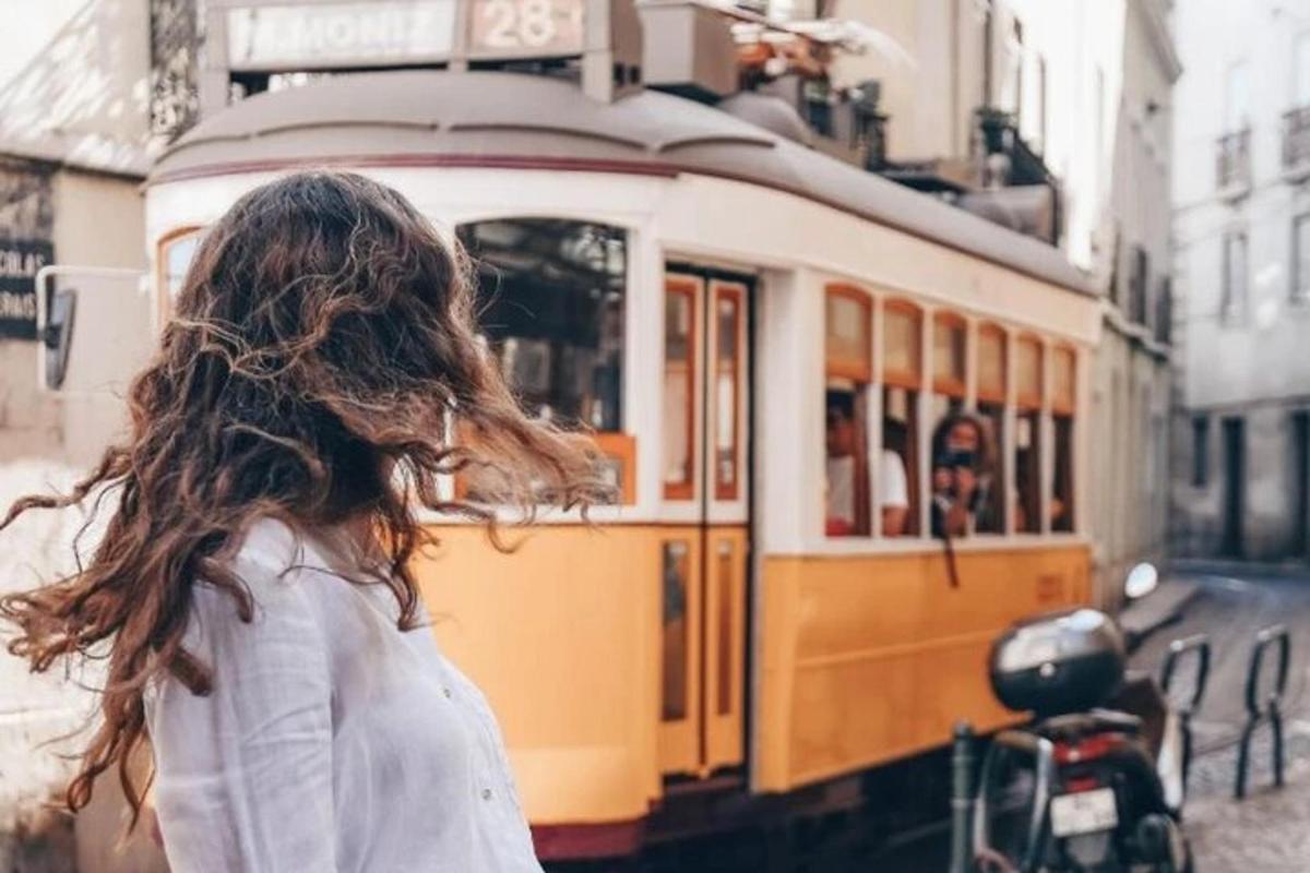 μια γυναίκα στέκεται μπροστά από ένα τραμ