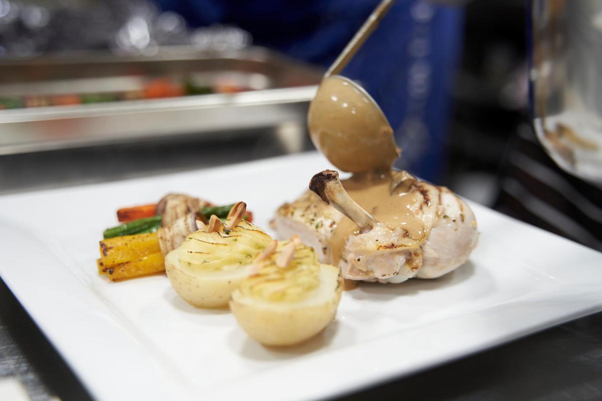 a plate of food with food being drizzled with sauce