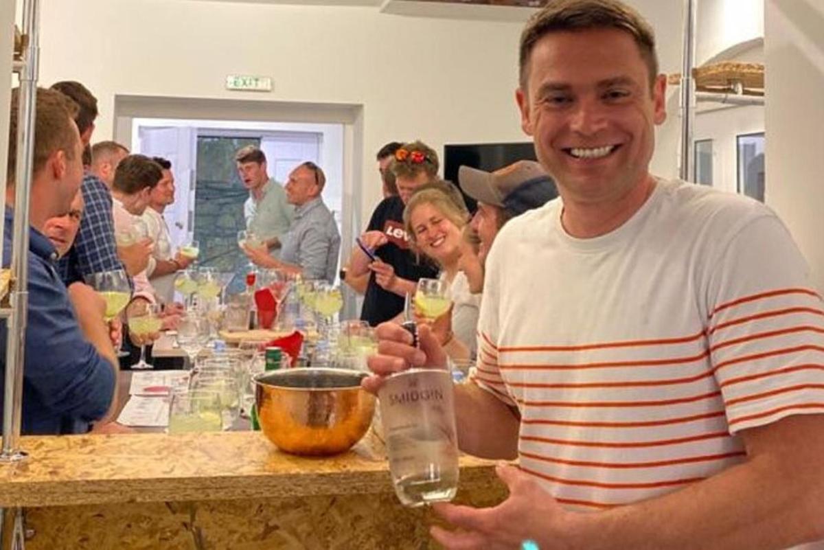 a man sitting at a table holding a glass